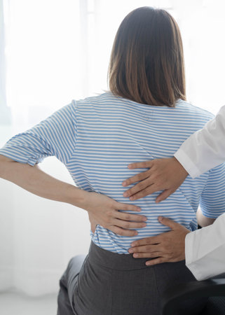Female physiotherapists provide physical assistance to women patients with back injuries back massages for relaxation and muscle recovery in the rehabilitation center.の写真素材