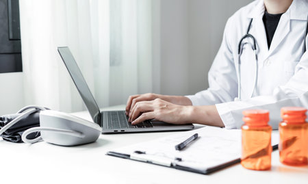 The female doctor sat and checked the patient's history and used a laptop to record patient information at the hospital. Medical concepts and interests.の写真素材