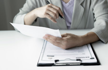 Business woman employer holding resume hiring recruit looking cv resume to hire candidates, analyzing information before job interview. Recruitment concepts.の写真素材