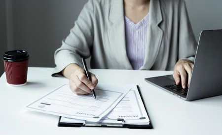 Business woman employer holding resume hiring recruit looking cv resume to hire candidates, analyzing information before job interview. Recruitment concepts.の写真素材