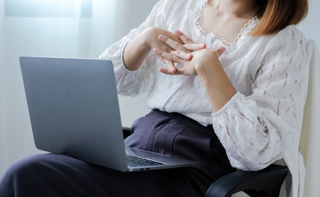 Asian female accountant is tired from working in a chair, stretching to relax and relax while...