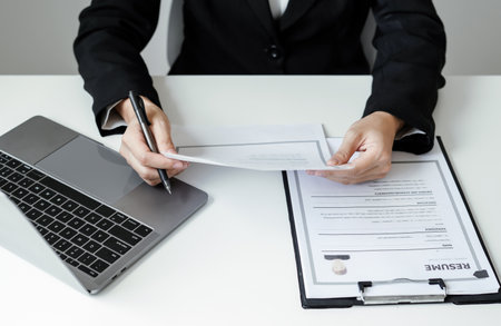 Business woman employer holding resume hiring recruit looking cv resume to hire candidates, analyzing information before job interview. Recruitment concepts.の写真素材