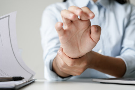 Woman hand with wrist pain numbness and pain in the palm of the hand has pain and tingling in the nerve endings This is a side effect of sitting and working for a long time on a laptop at the office.の写真素材