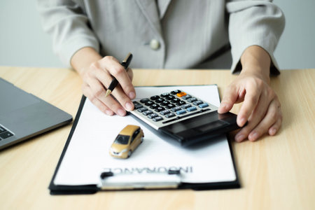 Car dealer businessWoman signing car insurance document or lease paper. Car loan and insurance concept.の写真素材