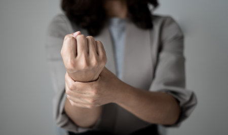Woman hand with wrist pain numbness and pain in the palm of the hand has pain and tingling in the nerve endings This is a side effect of sitting and working for a long time on a laptop at the office.の写真素材