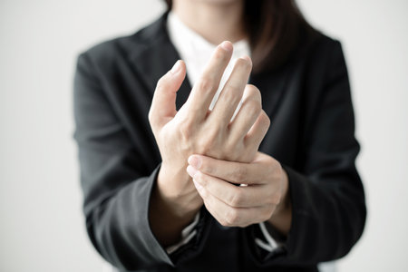 Woman hand with wrist pain numbness and pain in the palm of the hand has pain and tingling in the nerve endings This is a side effect of sitting and working for a long time on a laptop at the office.の写真素材