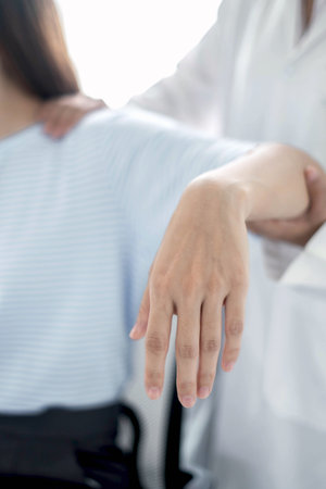 Female physiotherapists provide physical assistance to women patients with elbow injuries examine patients in rehabilitation centers. Physiotherapy concepts.の写真素材