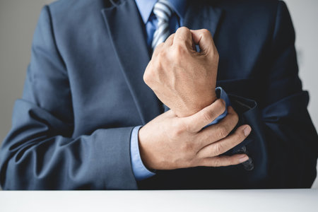 man hand with wrist pain numbness and pain in the palm of the hand has pain and tingling in the nerve endings This is a side effect of sitting and working for a long time on a laptop at the office.の写真素材