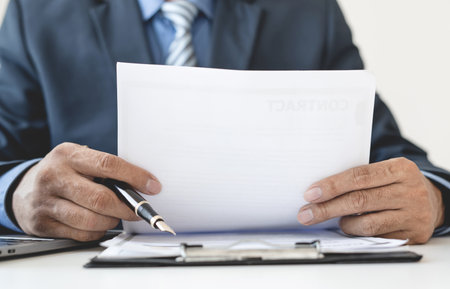 Business man employer holding resume hiring recruit looking cv resume to hire candidates, analyzing information before job interview. Recruitment concepts.の写真素材