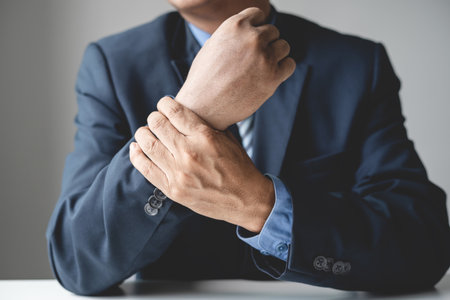 man hand with wrist pain numbness and pain in the palm of the hand has pain and tingling in the nerve endings This is a side effect of sitting and working for a long time on a laptop at the office.の写真素材