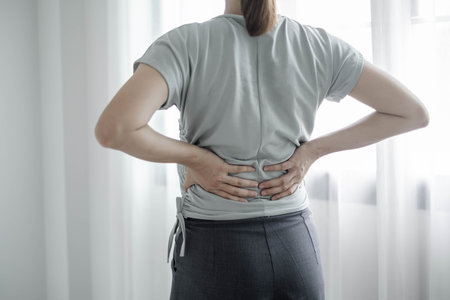 Woman having back body pain during work long time. stretching to relax and relax while working hard at the office.の写真素材