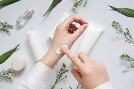 Scientist/Pharmacist applying moisturizer lotion on her hand for efficacy testing of natural organic...