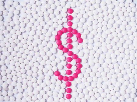 Dollar or money sign made by pink pills among many white tablet. Creative medicine idea for health...