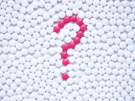Question mark formed by unique pink pills among white ones background. Creative medicine for health/medical problem, drug information services, medication error and pharmacy concept.の写真素材