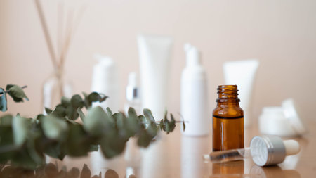 Serum or essential oil w/ organic herbal extract. Brown glass vial w/ dropper and skincare bottles on wooden table. Natural cosmetic, spa, beauty product and aromatherapy concept.の写真素材
