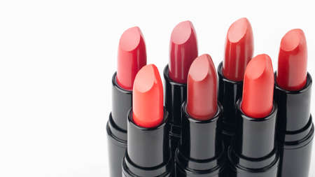 Set of red lipsticks in black tube package on white background. Makeup and cosmetics concept. Close...
