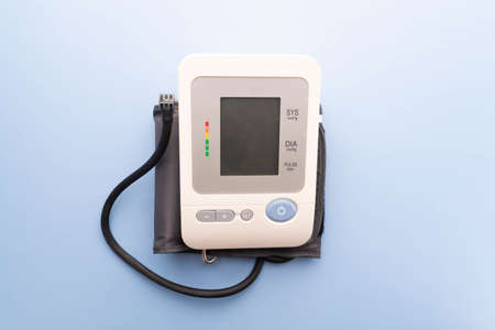 Automatic blood pressure monitor on light blue background. Copy space.の写真素材