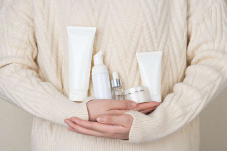 Skincare daily routine for healthy skin. Woman hands holding skincare product set included facial foam, cleanser, serum, moisturizer cream and body lotion packaging. Beauty and cosmetic concept.の写真素材