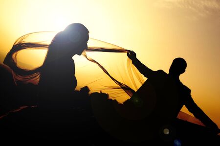 silhouette of two newlyweds at sunsetの写真素材
