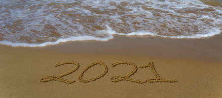 Happy new year 2021 written in the sand. Happy new year 2021 written in the sand by the sea.