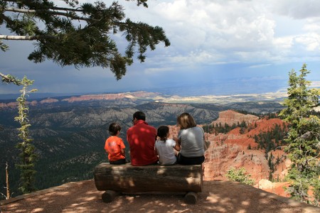 family of four relaxing on the bench at the edge of the canyonの写真素材