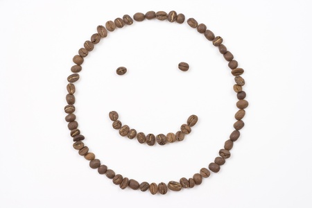 smiley face made out of coffee beans on white backgroundの写真素材