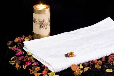 a white towel burning candle and dried flowersの写真素材