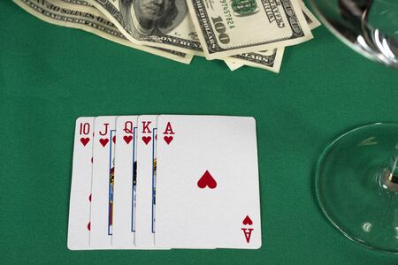 poker cards on green table with dollars