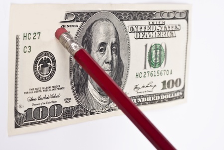 erasing a 100 dollar bill with a red pencil and eraserの写真素材