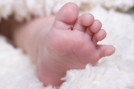 single small newborn baby foot on soft blancket の写真素材