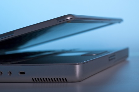 silver laptop on blue light background with the lid openの写真素材