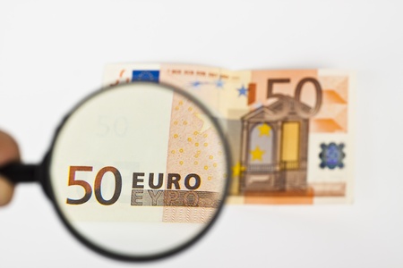 fifty  euro with magnifying glass on white backgroundの写真素材