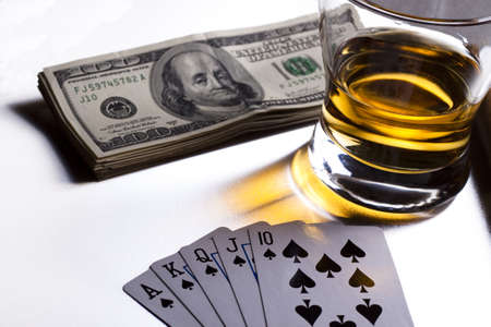 poker playing cards dollars and a whiskey glassの写真素材