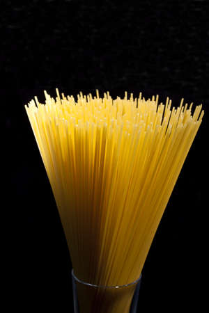 spaghetti in a glass abstrack light in black backgroundの写真素材