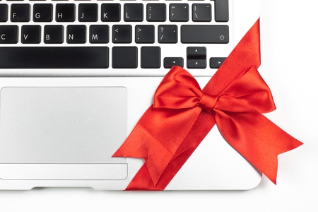 open silver laptop gift with red ribbon keyboard and trackpad closeup  isolated on white backgroundの写真素材