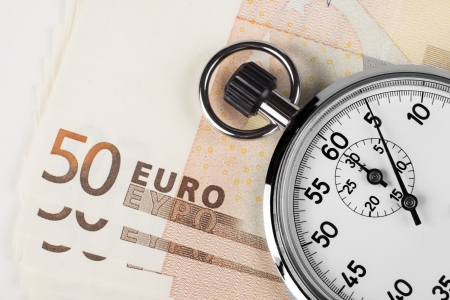 stopwatch closeup pointing at 5 seconds on a pile of 50 euro bills isolated on white background