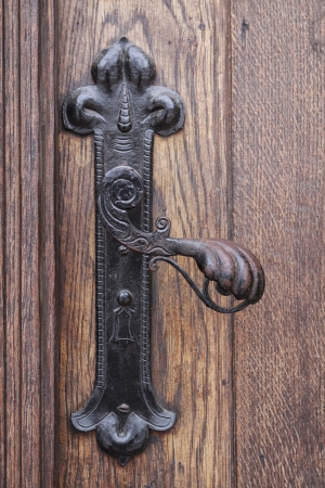 Ancient rusty church door handle on brown old wooden doorの写真素材