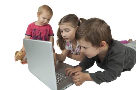 Children group two girls and one boy playing on a silver laptop isolated on white background