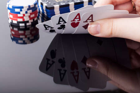 Woman holds aces poker cards with reflection