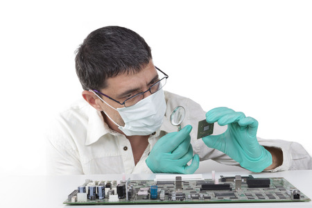 Man repairing microchip electronic equipment with mangifying glass on white background