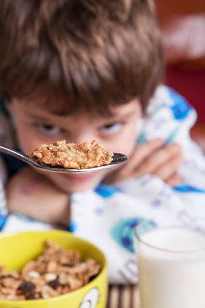 Macro shoot of cereals on teaspoon with little boy 