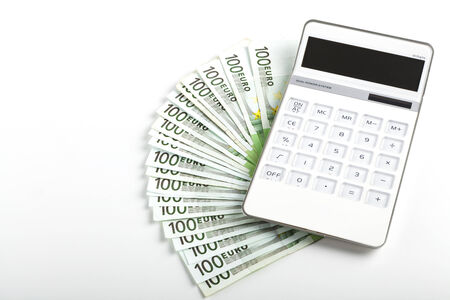 One hundred Euro banknotes with white calculator isolated on white backgroundの写真素材