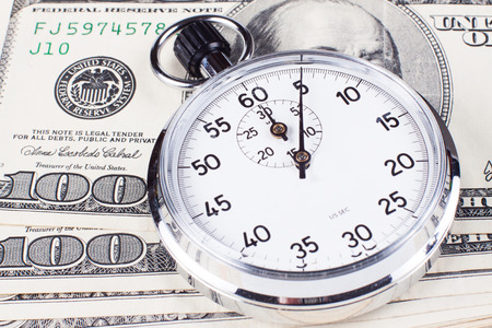 Hundred dollar banknotes with analog silver stopwatch close-upの写真素材