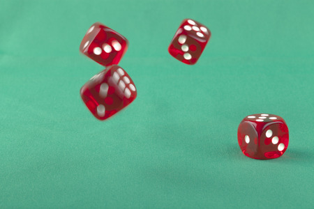 Four red bouncing dice On green background with some shadow