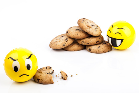 Sad Smiley and happy smiley with chocolate chips cookiesの写真素材