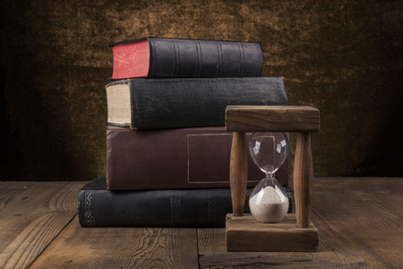 Old Books on Wood Table With Hourglass