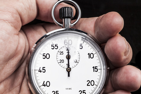 Chronometer in hand isolated on black backgroundの写真素材