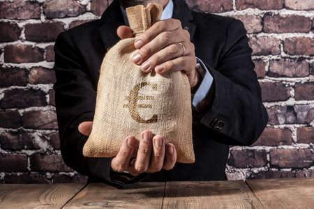 Man holding a big sack of moneyの写真素材