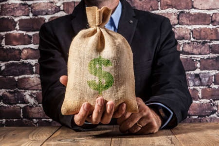 Man holding a big sack of moneyの写真素材