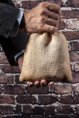 Man holding a big sack of moneyの写真素材